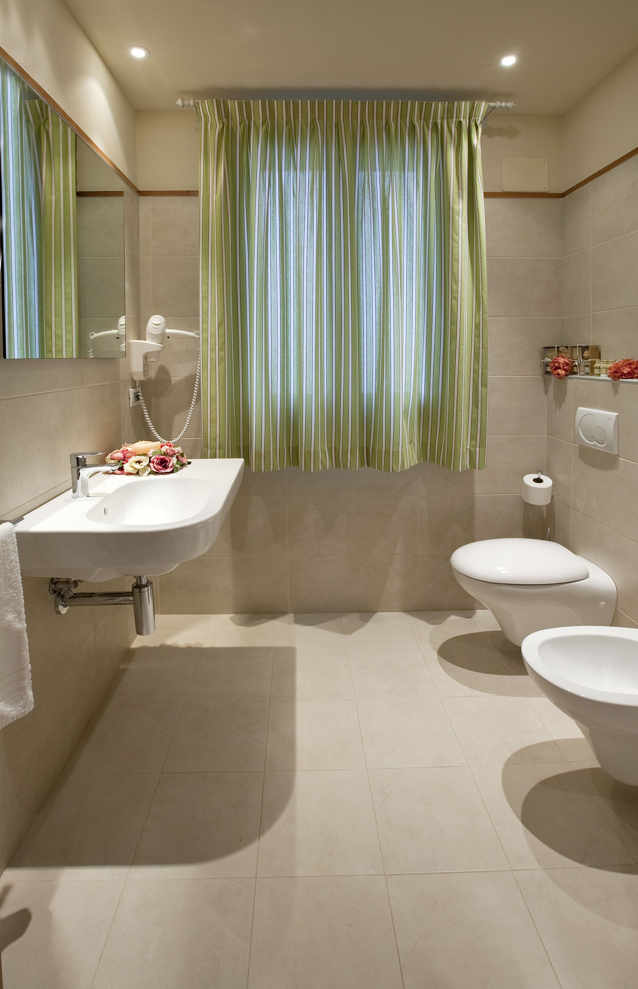 Une salle de bain avec un lavabo blanc, des toilettes et un rideau de douche.