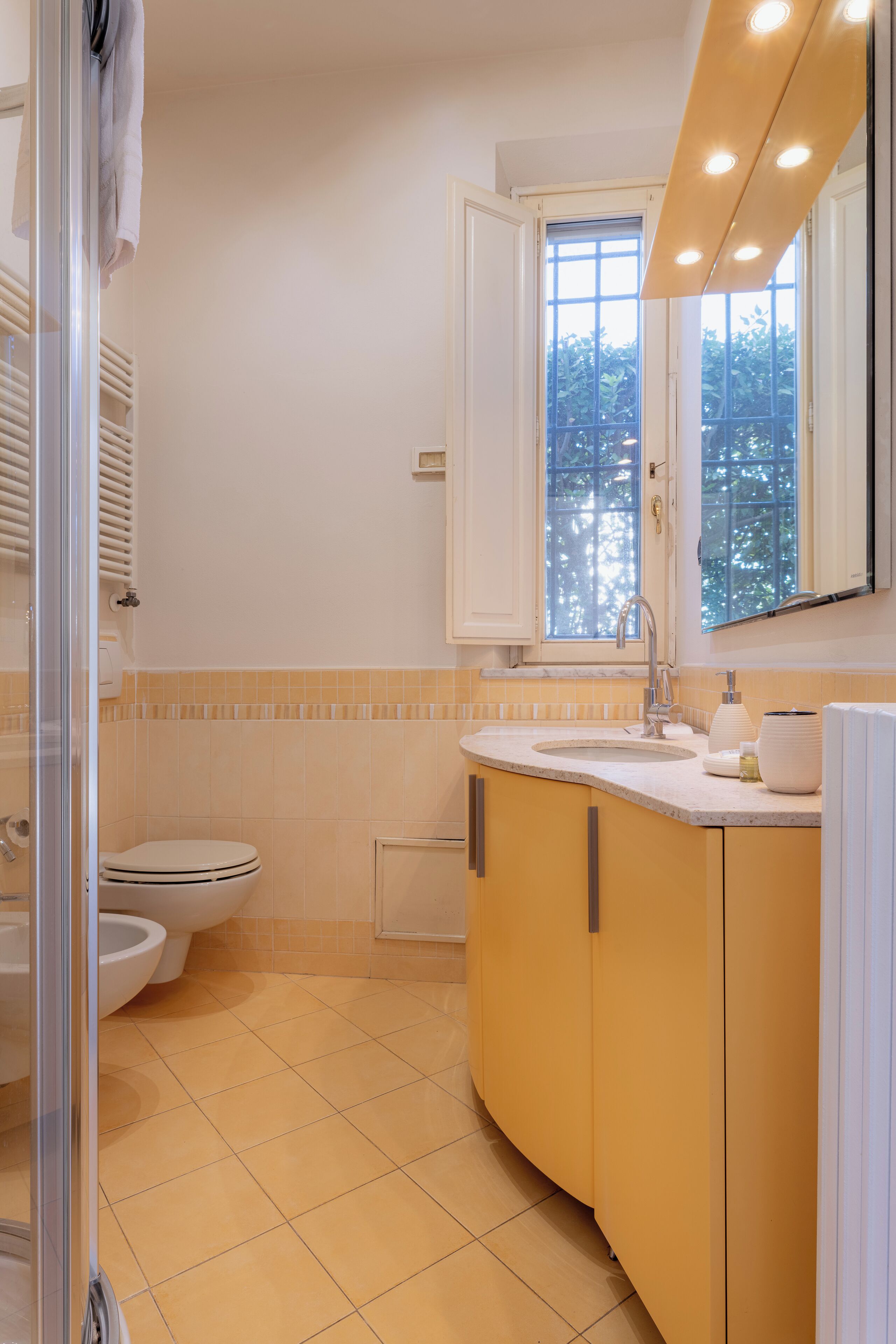 Un baño con inodoro, lavabo y zona de ducha.