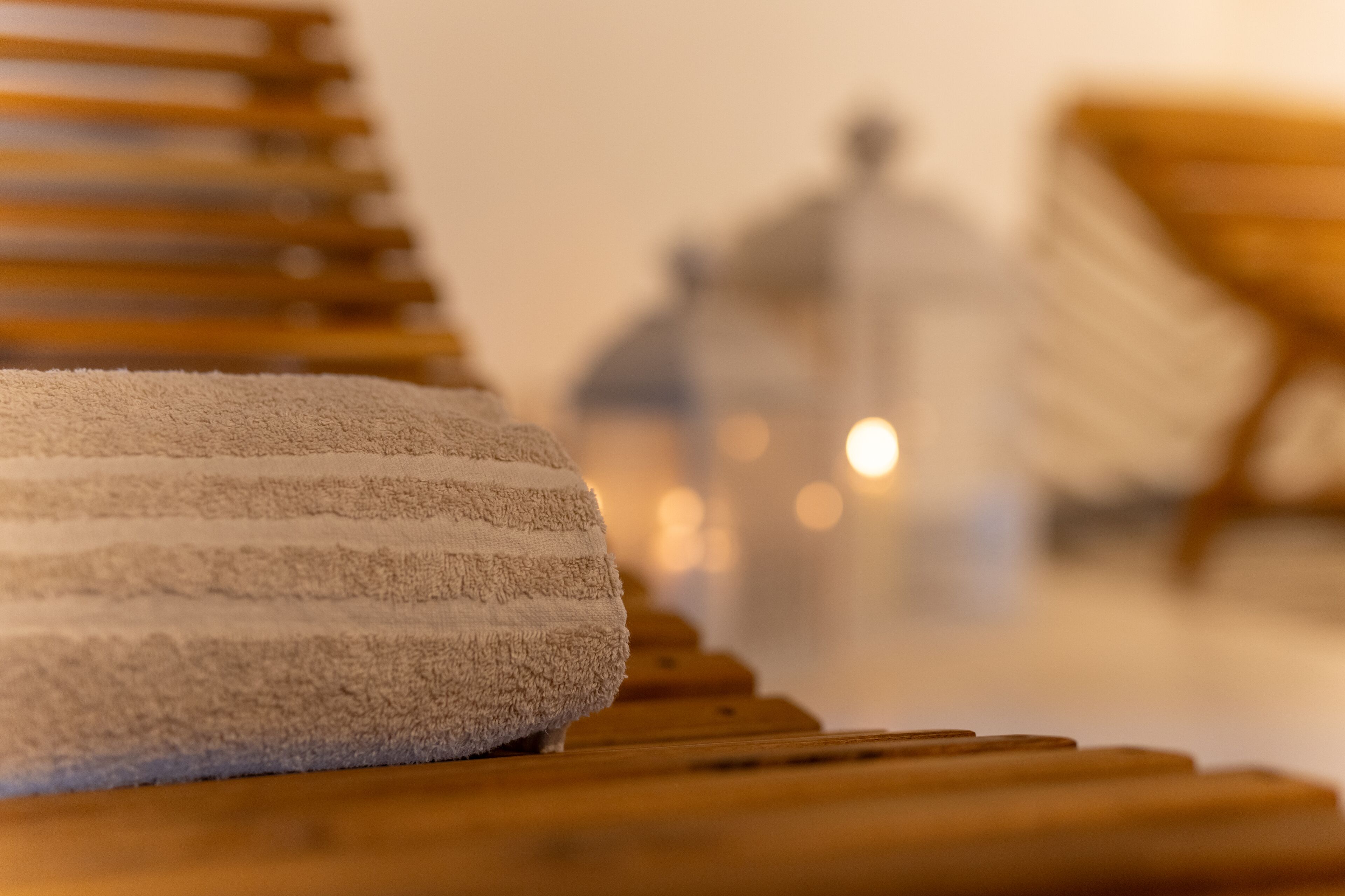 Ein Handtuch auf einer Holzbank in einer Wellness-Umgebung.