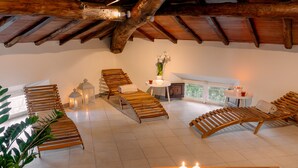 Un'ampia stanza con poltrone in legno, un tavolino con candele e vista sull'esterno.