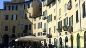 Une cour bordée de bâtiments, avec des espaces de repos en plein air et un ciel dégagé.