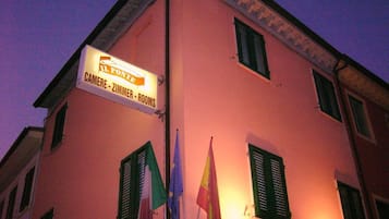 A building with a sign indicating it offers rooms and a restaurant.