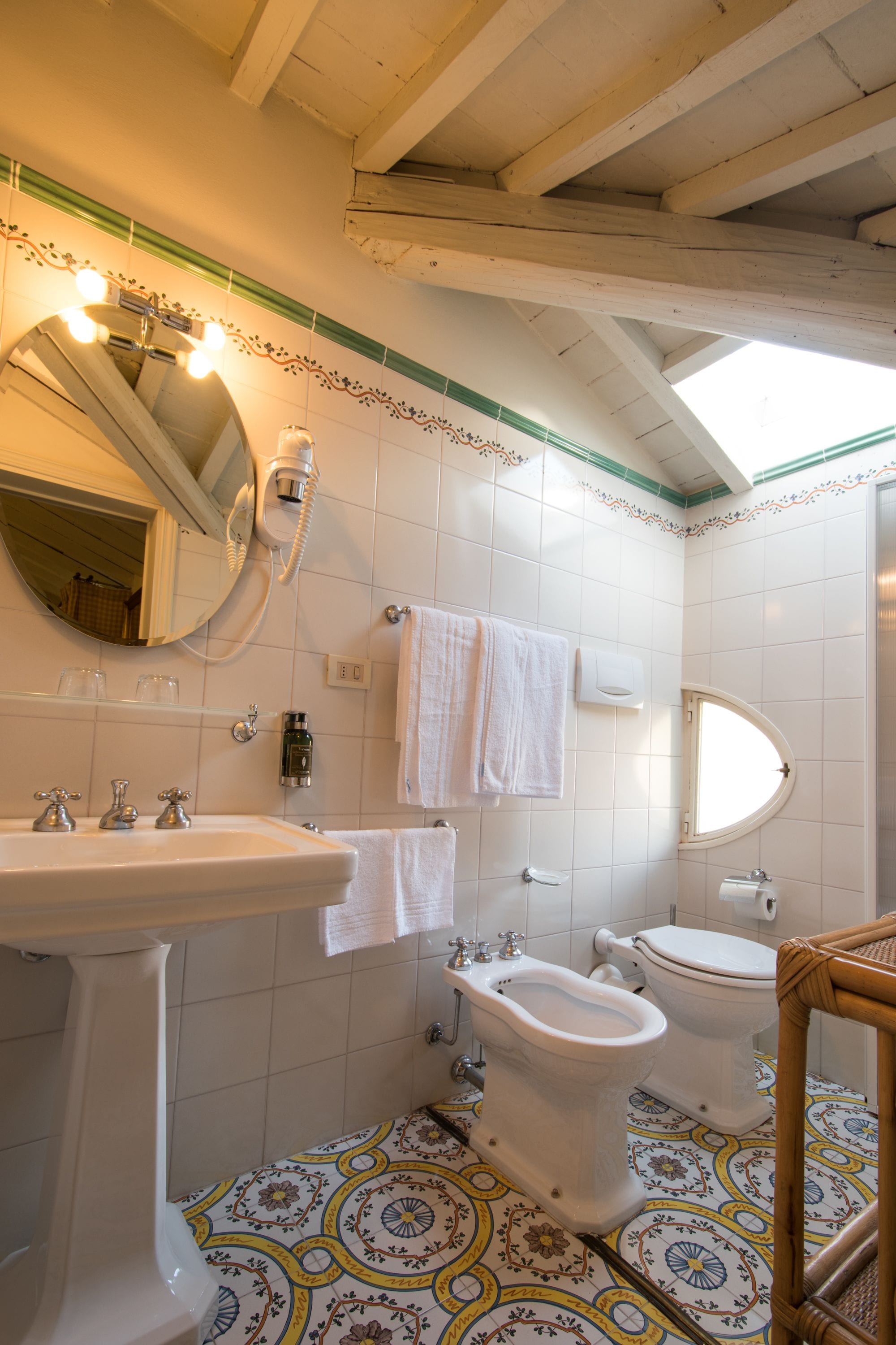 A bathroom with a sink, bidet, toilet, and a mirror.