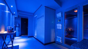 Una moderna camera d'albergo con un letto grande, un comodino e una finestra.