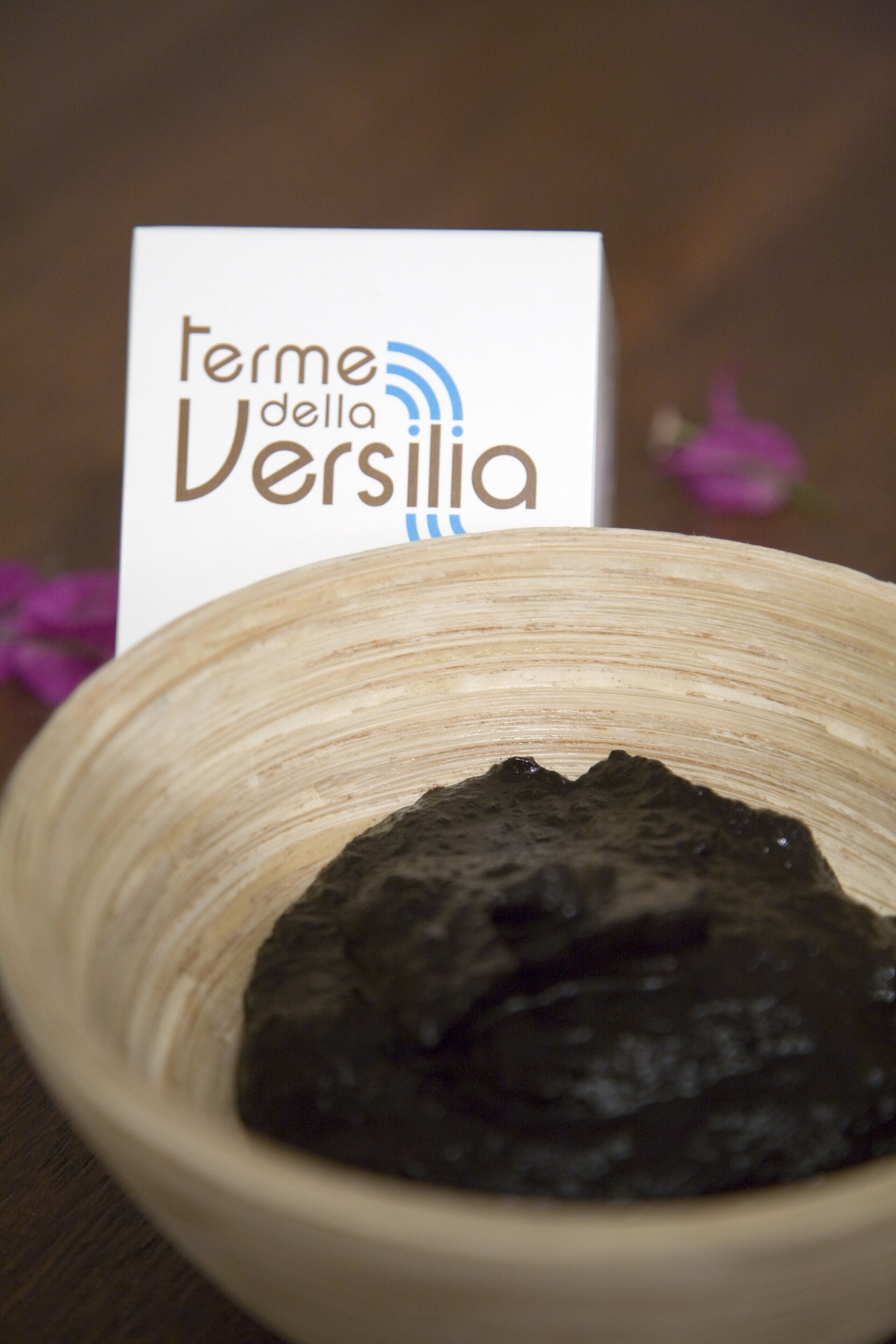 A bowl of dark substance with a white label in the background.