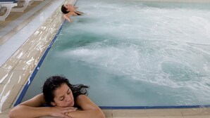 An indoor swimming pool with clear water, tiled floor, and sunlit ceiling. - Hotel Villa Undulna - Terme della Versilia (Montignoso)