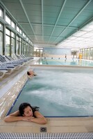 Una piscina techada, abierta desde las 10:00 hasta las 20:00, sombrillas