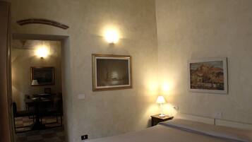 Ein Hotelzimmer mit Bett, Schreibtisch und zwei Bildern an der Wand.