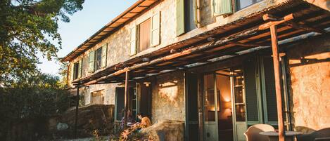 A rustic stone building with a covered patio and outdoor seating area.