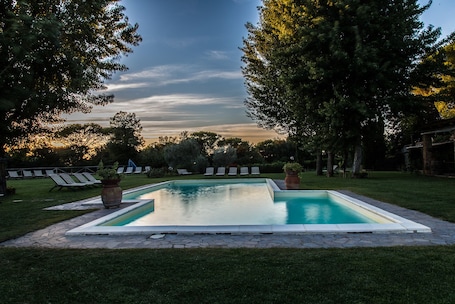 Una piscina al aire libre de temporada, sombrillas, tumbonas