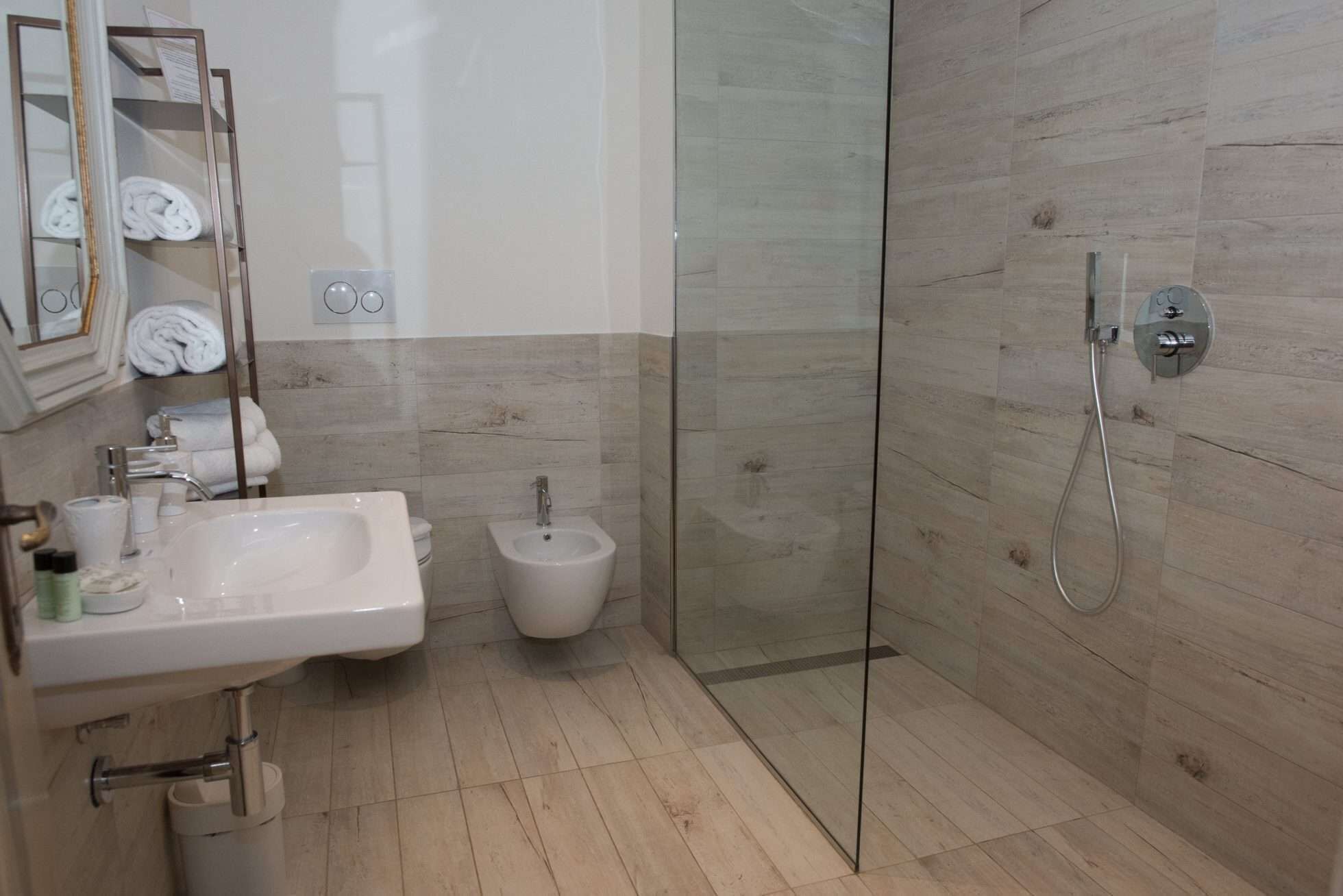 A modern bathroom with a glass shower enclosure, a sink, and a bidet.