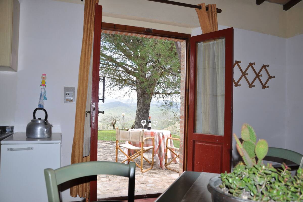 Un coin repas accueillant, avec une table dressée pour deux personnes, une bouilloire et une plante en pot.