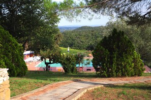 Een buitenzwembad, parasols bij het zwembad en ligstoelen
