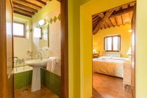 A bathroom with a sink, mirror, and green-tiled walls. - Tenuta di Monaciano (Castelnuovo Berardenga)
