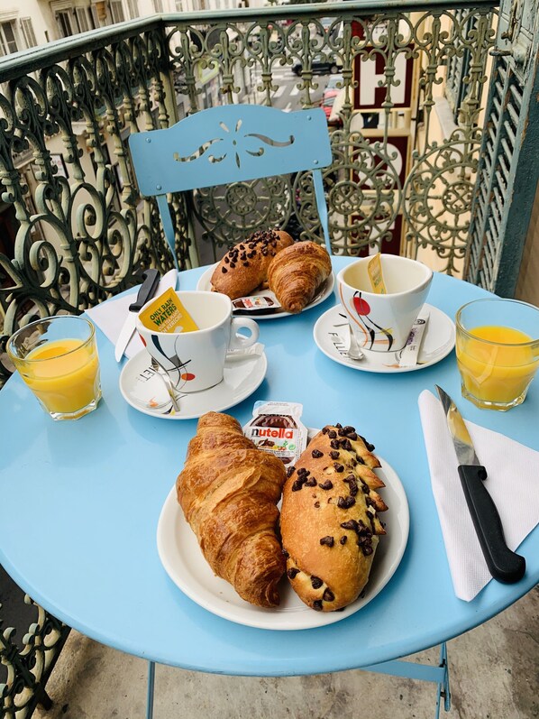 Una mesa con croissants, Nutella y zumo de naranja.