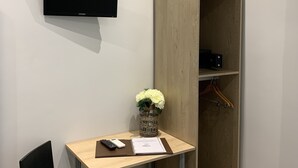 Una habitación pequeña y moderna con escritorio, silla y armario.