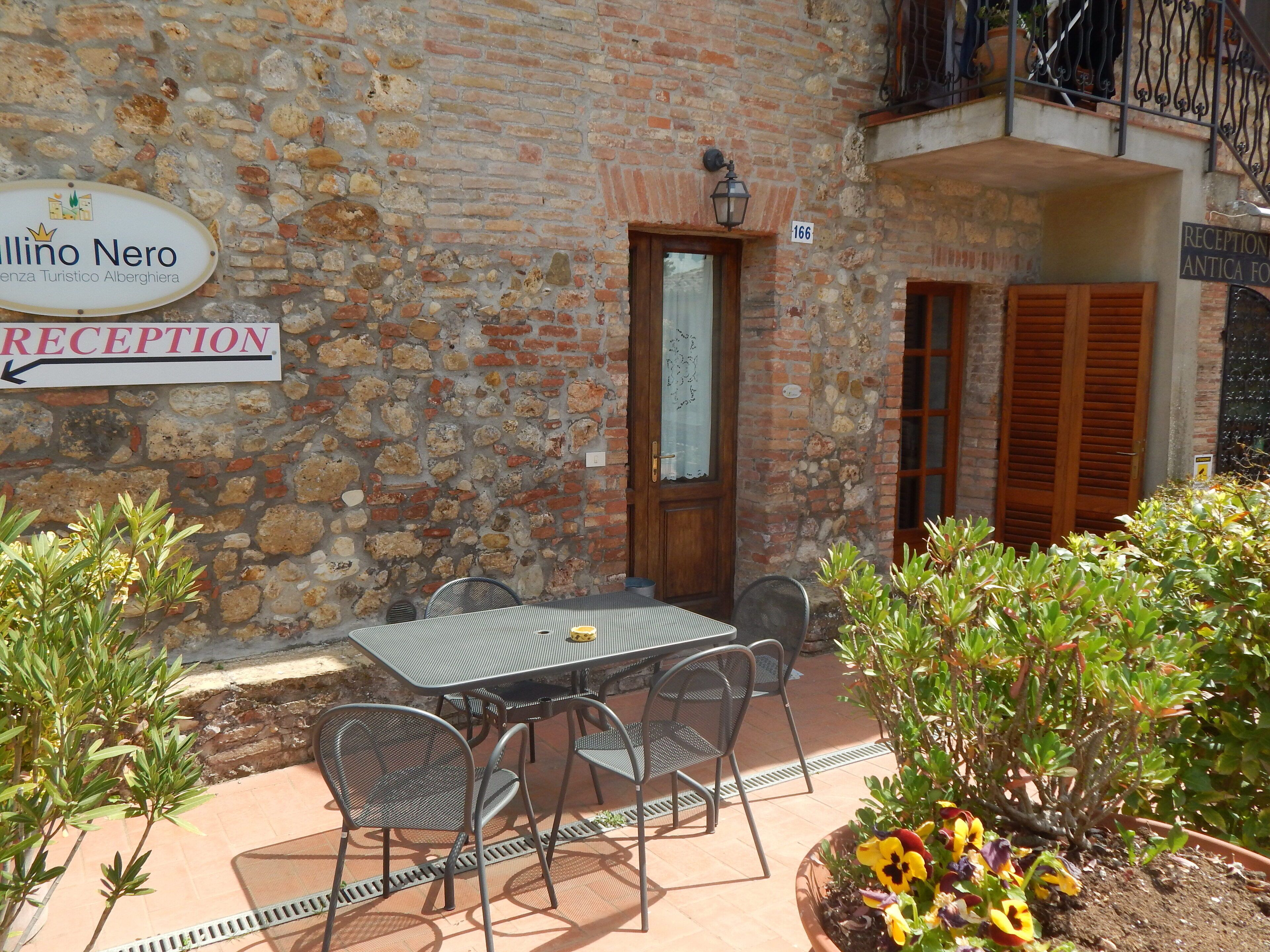 A reception area with a stone wall, a wooden door, and a sign indicating the reception.