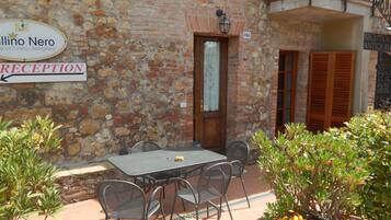 A reception area with a stone wall, a wooden door, and a sign indicating the reception.