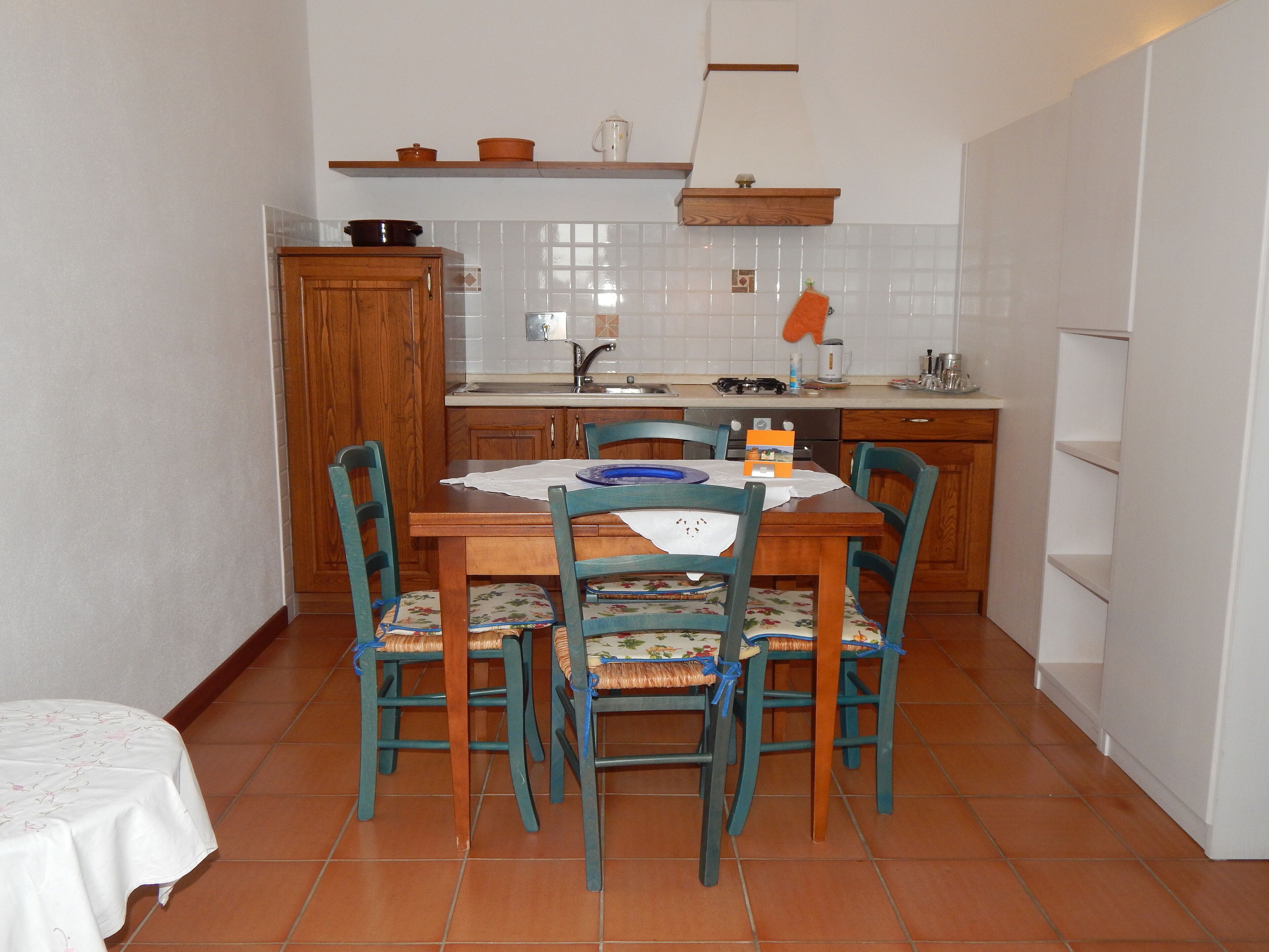 Une cuisine de taille réduite comprenant une table à manger, des chaises et un petit plan de travail.