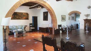 A spacious living area with a fireplace, a dining table, and a large mirror. - Il Poderaccio (Siena)