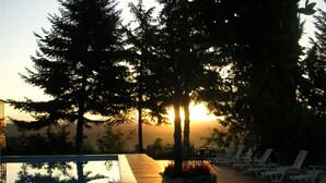 A poolside area with lounge chairs and a sunset view. - Il Poderaccio (Siena)