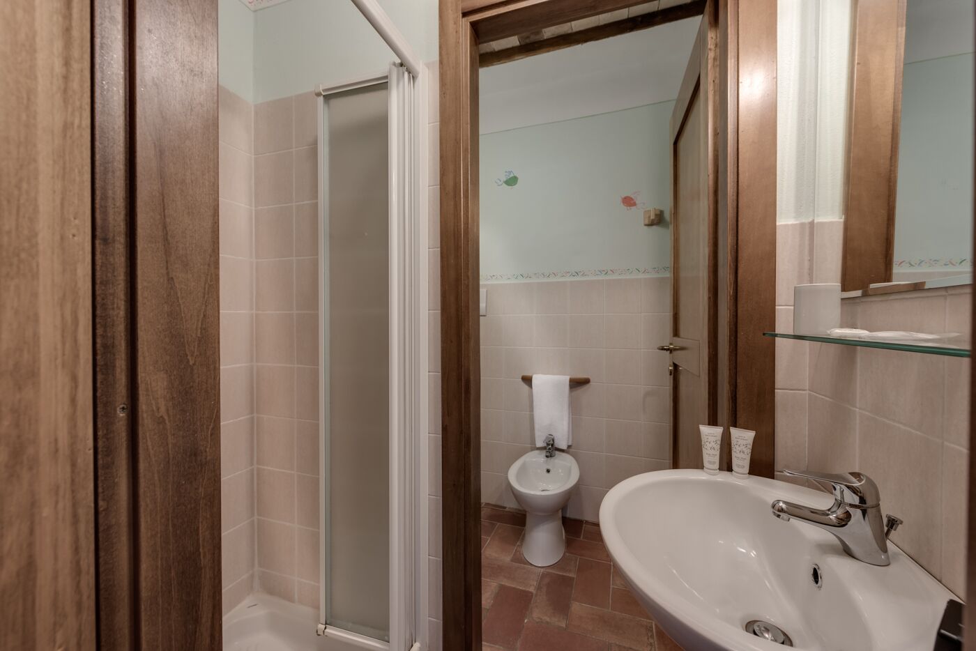 A bathroom with a shower, toilet, and sink.