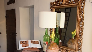Un bureau en bois avec un miroir, un vase de fleurs et une bougie.
