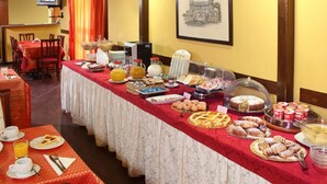 A buffet setup with various food items and a television in the background. - Cassia Hotel (Rome)