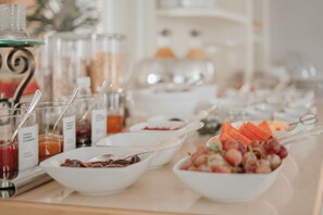 A buffet table with various food items and beverages.