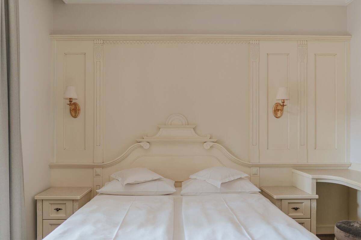 A bedroom with a double bed, two bedside tables, and a nightstand.