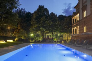 Una piscina al aire libre de temporada, sombrillas