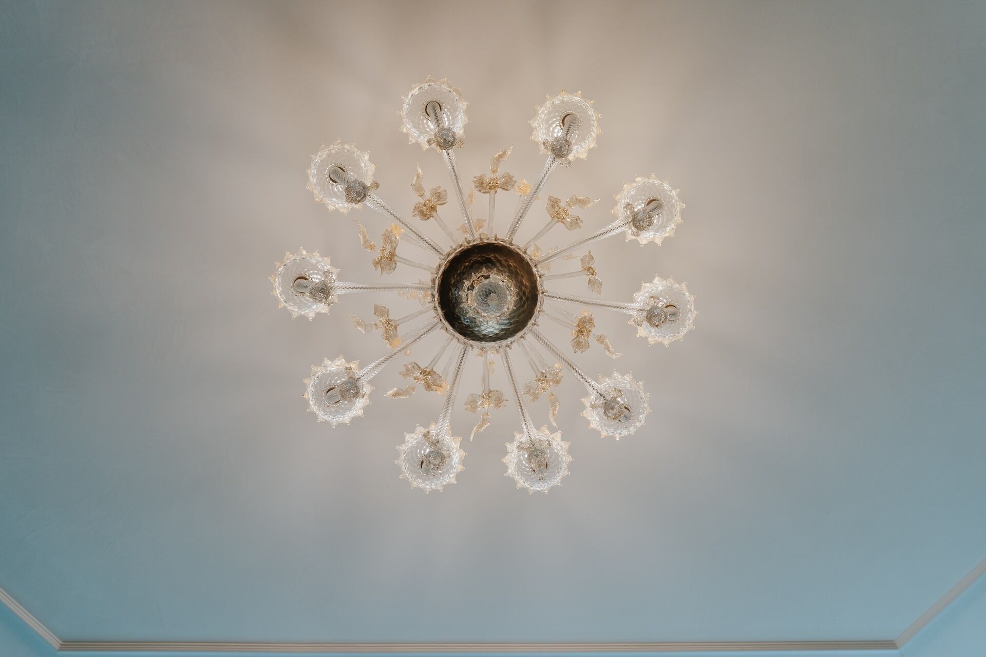 A ceiling with a central circular design surrounded by multiple arms, each ending in a clear, crystal-like structure.