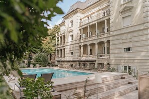 Una piscina al aire libre de temporada, sombrillas