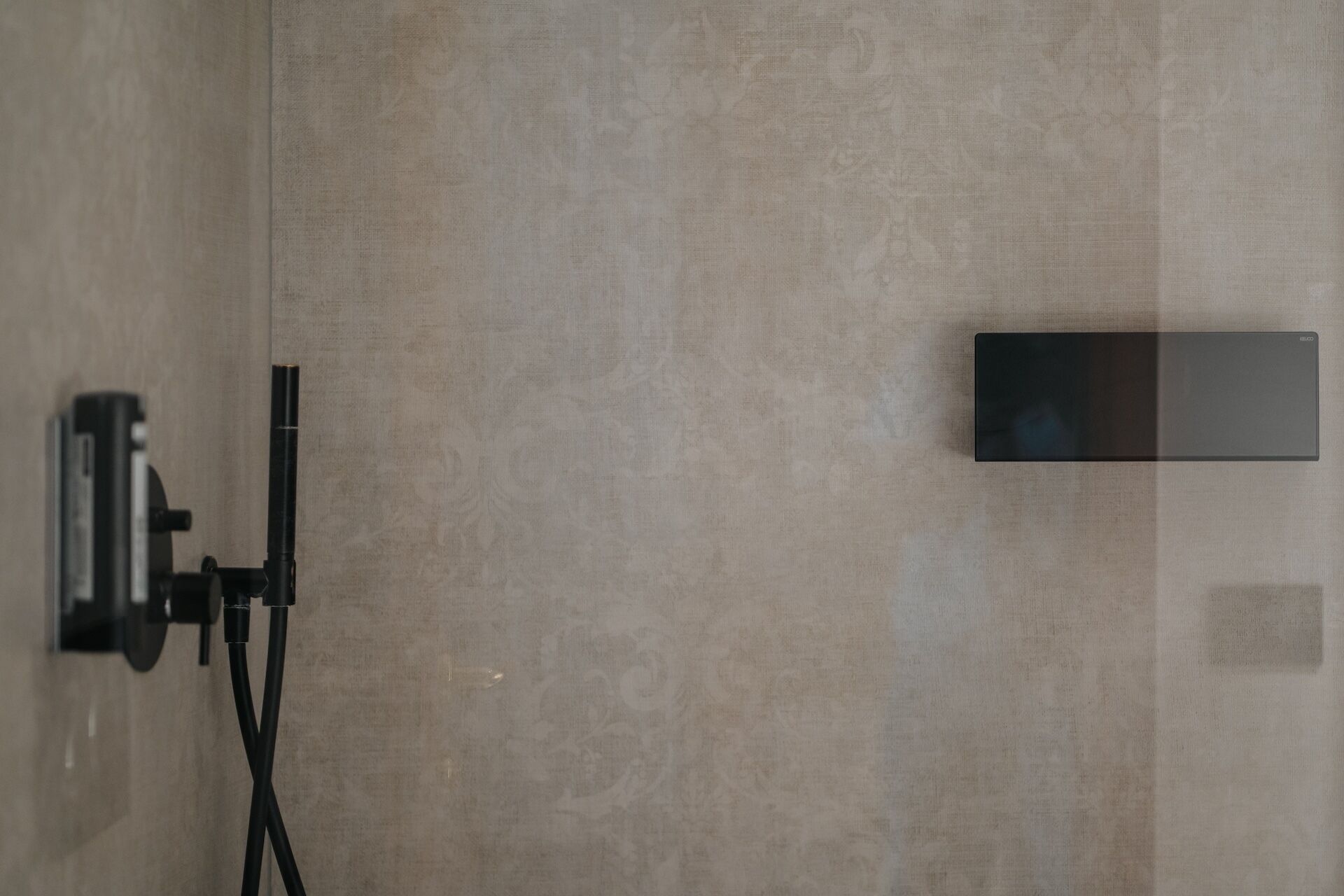 A bathroom with a towel rack, a mirror, and a wall-mounted light fixture.