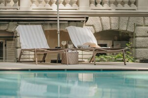Una piscina al aire libre de temporada, sombrillas