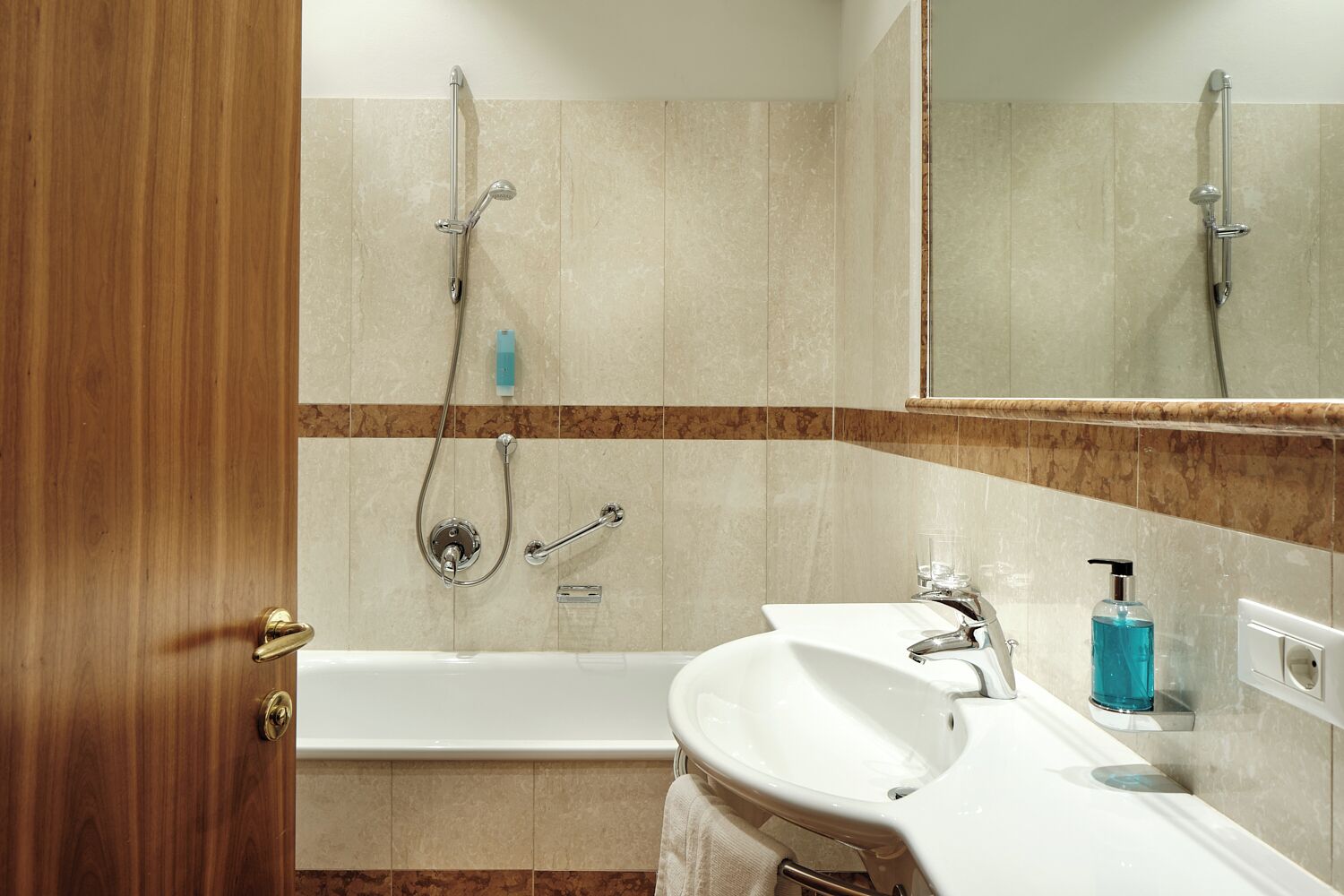 A bathroom with a bathtub, a sink, a mirror, and a shower.