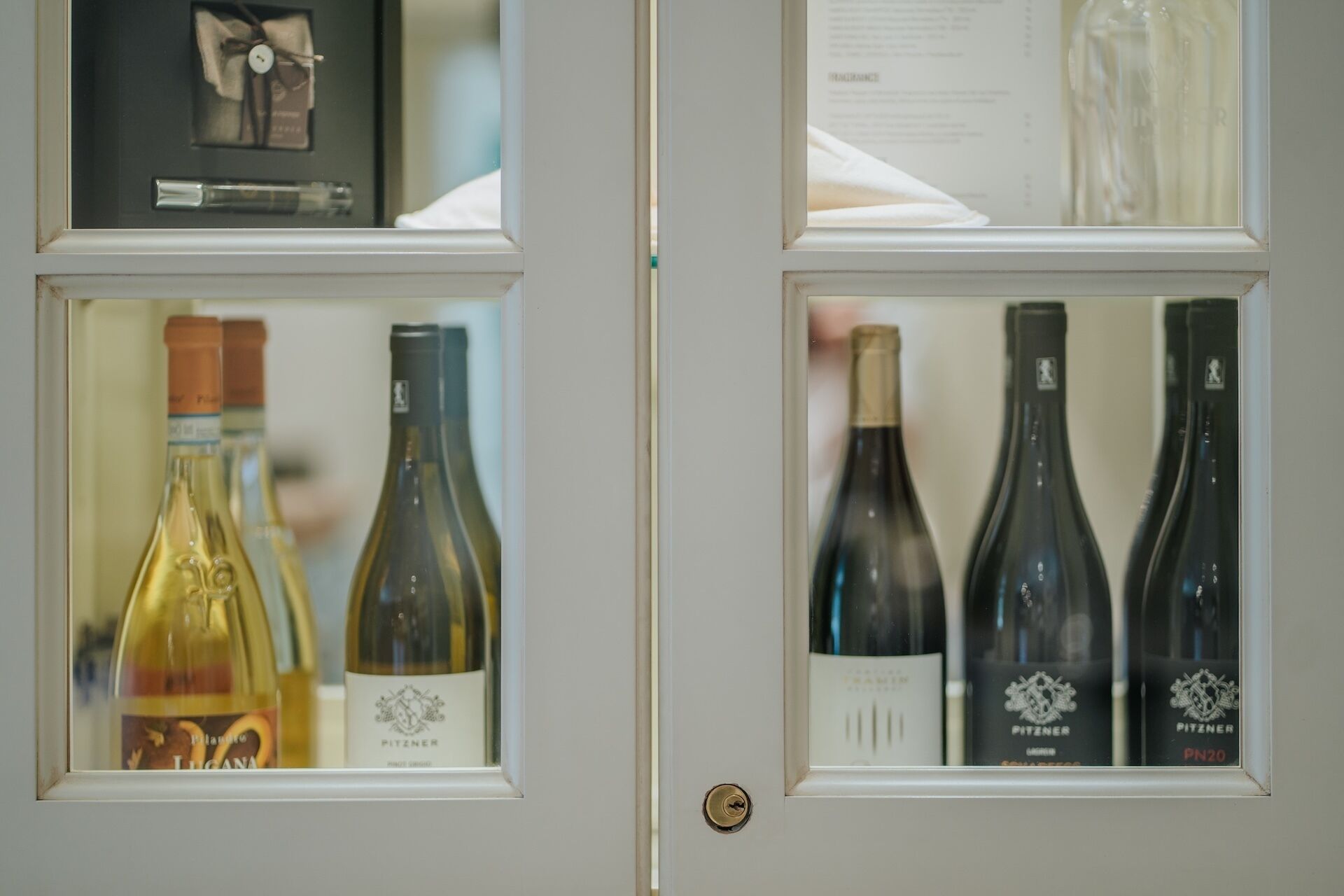 Una puerta con dos paneles de vidrio, cada uno con botellas de vino.