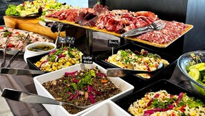 Un buffet proposant une variété de plats, notamment des viandes, des salades et des légumes.