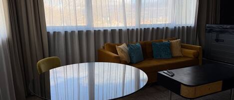 Una habitación con una mesa redonda, un sofá y una silla.