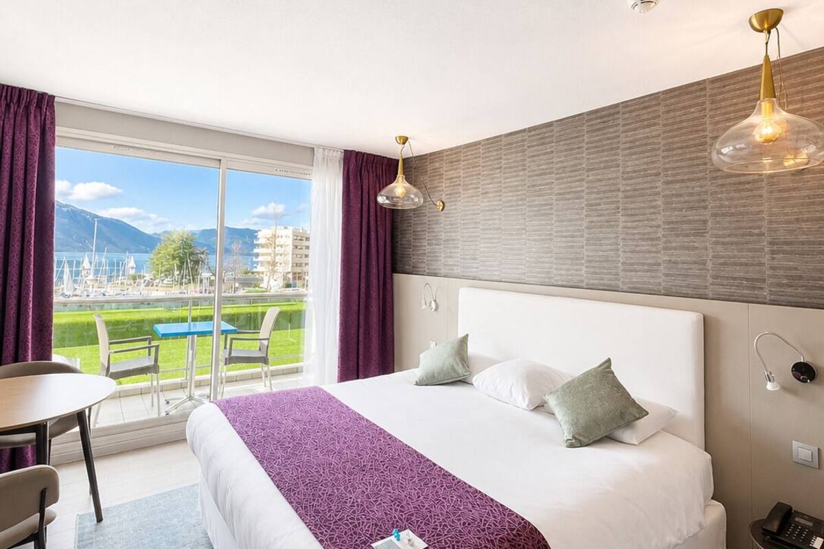 Een hotelkamer met een groot bed, een bureau en uitzicht op een golfbaan.