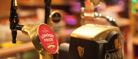 Dos grifos, uno con la etiqueta 'London Pride' y otro con la etiqueta 'Guinness', en un bar.