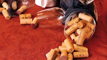 Uma mesa com garrafas de vinho, copos de vinho e rolhas.