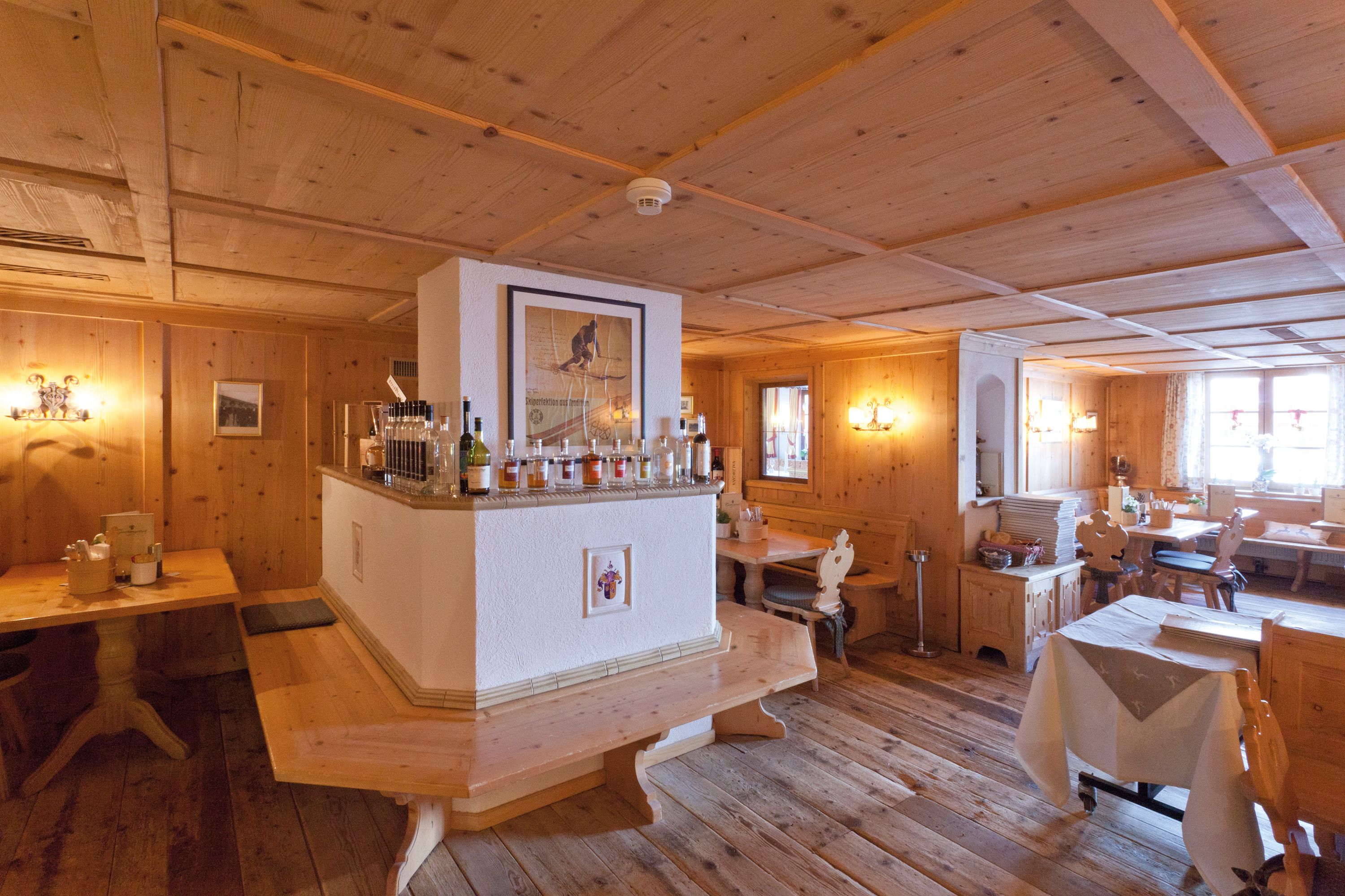 A wooden interior with a bar area, wooden tables, and benches.