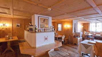 A wooden interior with a bar area, wooden tables, and benches.