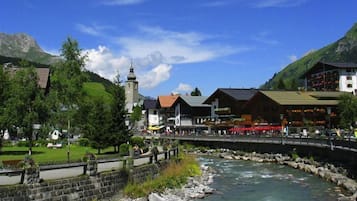 A riverside town with stone buildings, a church, and a bridge.