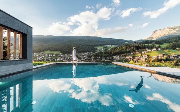 A swimming pool with a clear view of a town and mountains in the background. - Rainell Dolomites Retreat (Castelrotto)