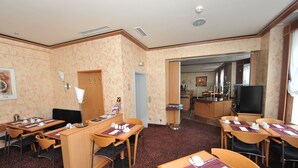 A hotel room with a dining area, a kitchenette, and a television. - Insel Hotel (Cologne)