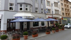 A hotel with outdoor seating and potted plants. - Insel Hotel (Cologne)