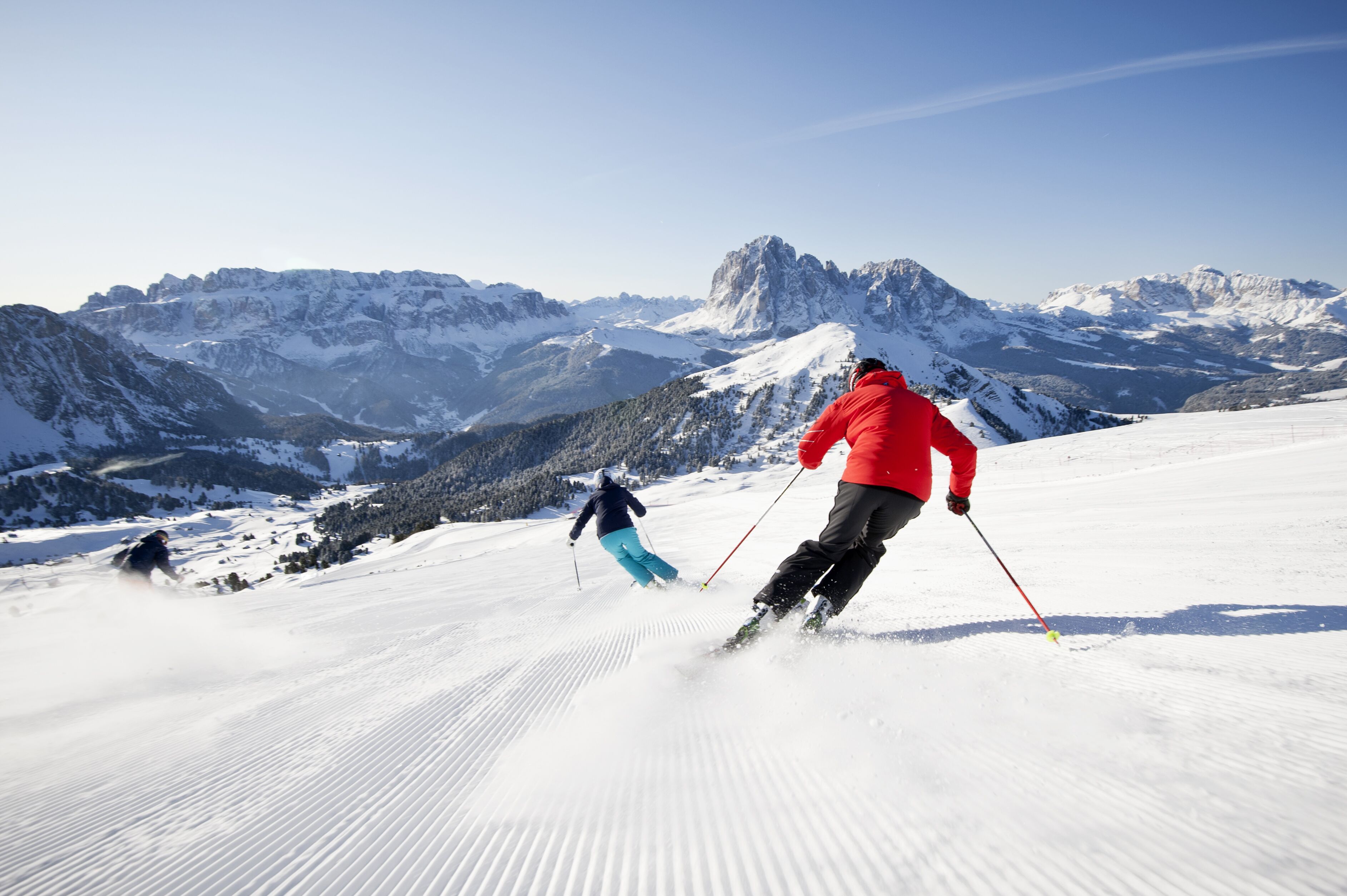 A snowy mountain landscape with skiers.