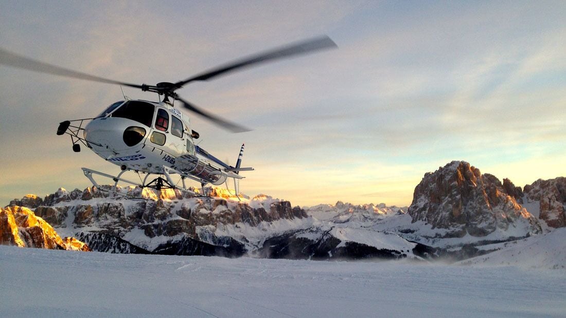 Un helicóptero volando sobre un paisaje montañoso nevado.